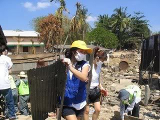 Local Thai aid workers clean up debris and destruction in the wake of the 2004 Indian Ocean tsunami.